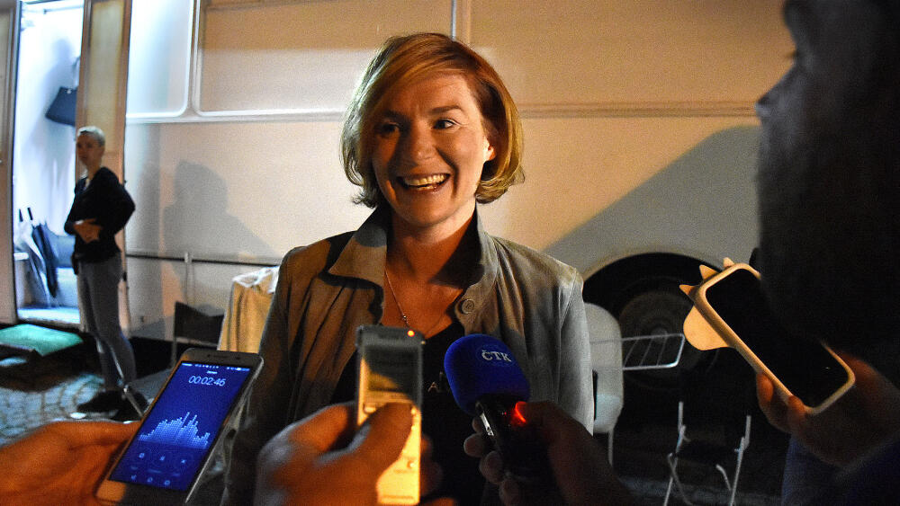 Lenka Krobotová v novinářském obklíčení.