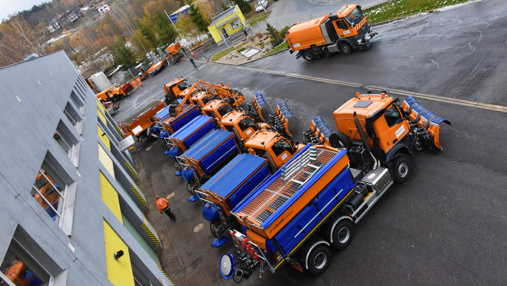 Vybraní zástupci 72 členné flotily zimní údržby, nově pořízená vozidla parkují v popředí.