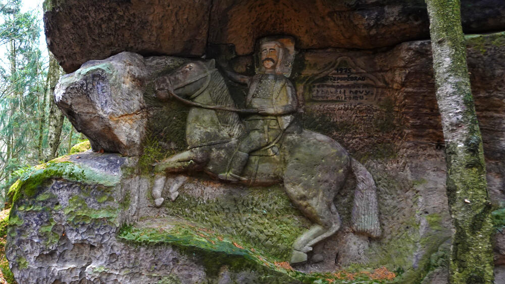 Jiřího z Poděbrad doprovází text: "Kdo chce všem vyhovět, nevyhoví nikomu." Tak to by se mělo tesat neustále a nejen do kamene.