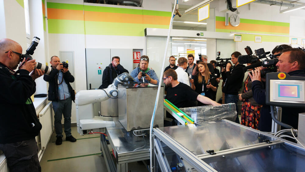 Roboty jsou zatím fascinováni i dospělí, jak dokumentuje fotka z prezentace kooperativního robota YuMi v květnu 2016.