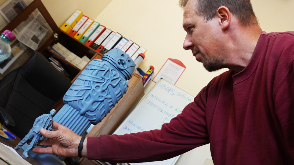 Vojtěch Mai, vedoucí těžby, který oba žulové monobloky ze skály vylámal, pro lepší představu přikládá figurku člověka ve velikosti odpovídající modelu. 
