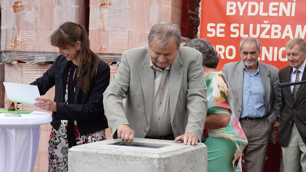 Jiří Drda zamyká schránku a ve stejném okamžiku Anna Ježková zjišťuje, že nebyla vložena listina s podpisy všech zúčastněných patronů projektu. Vzápětí se ukazuje, že schránku lze jen velmi těžko otevřít.