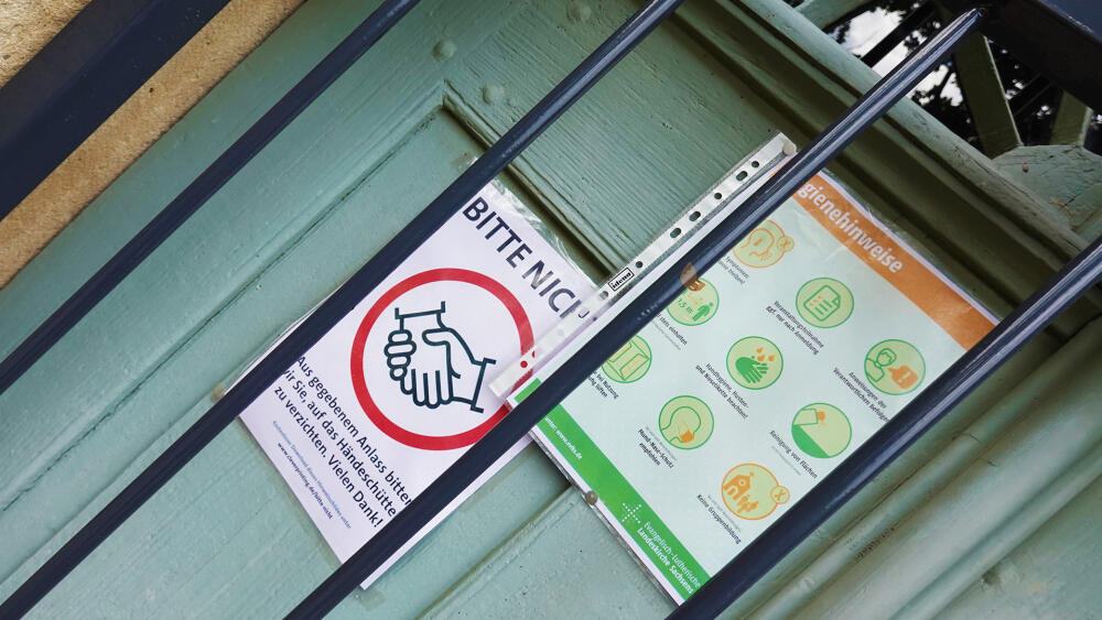 Hygienické instrukce jsou německy pečlivější a barevnější než u nás. (Na fotografii jsou pokyny kostela v Oybinu.)