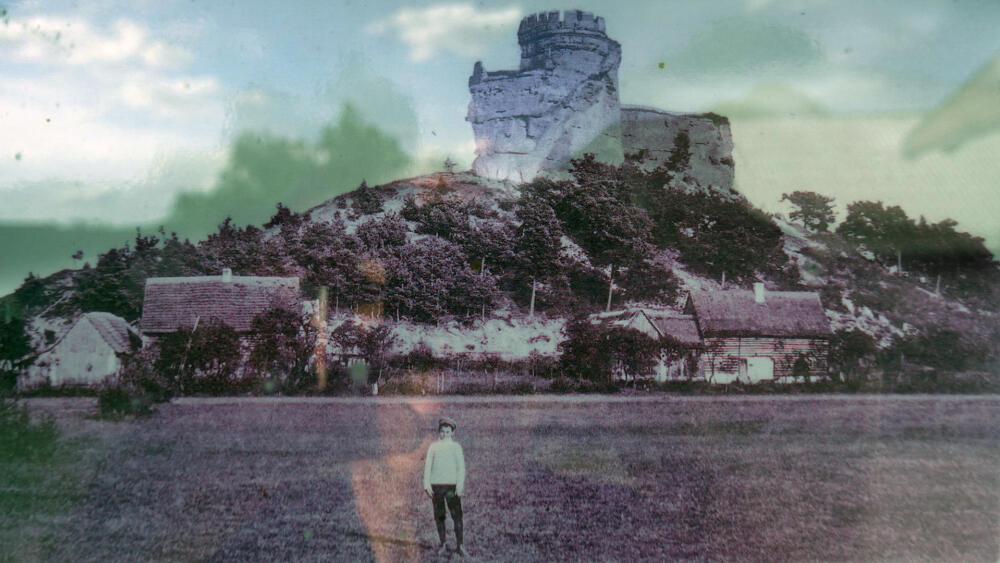 Jestřebí před tím, než se utrhl skalní blok nesoucí zbytky cimbuří. (Reprofoto z infopanelu.)