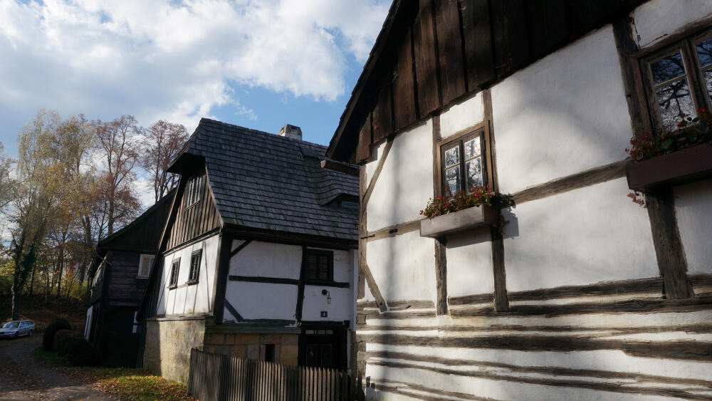 Cesta od letohrádku k Lemberku vede kolem stylových roubenek.