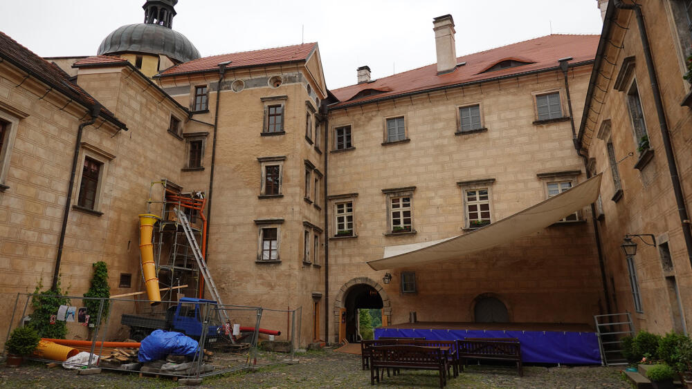 Na velkém nádvoří se protiklady přitahují. Vlevo vyrostlo staveniště, vpravo divadelní scéna.