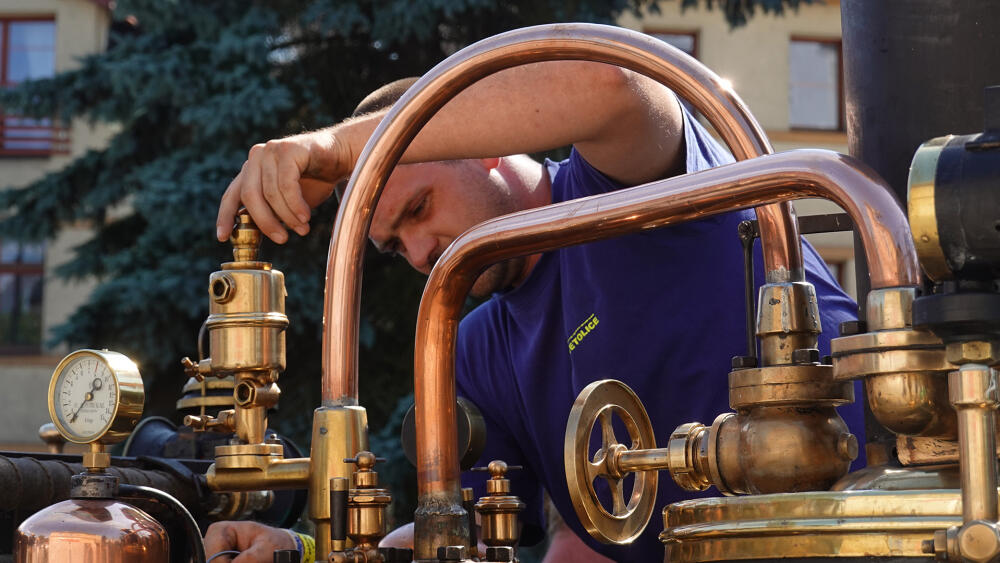 Seřizování mašiny. Dnes všechny ty trubky, kohouty a ciferníky vypadají jako dílo steampunkového výtvarníka. Přitom je vše ryze funkční, ani bez jediné takové "ozdoby" by stroj nefungoval.