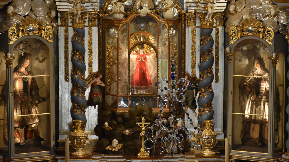 Hlavní oltář. Po pravici (z našeho pohledu tedy vlevo) Madony z Ploučnice stojí ostatková socha sv. Pavla, po levici sv. Kristiny. Zajímavé je, že sv. Kristina má skleněnou hlavu.
