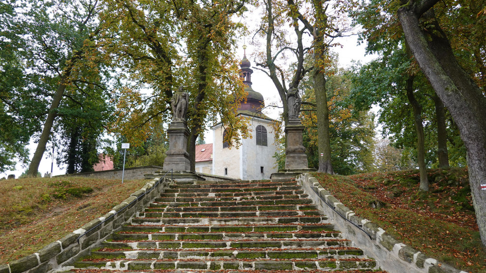 Schody ke kostelu sv. Barbory střeží sochy světců.