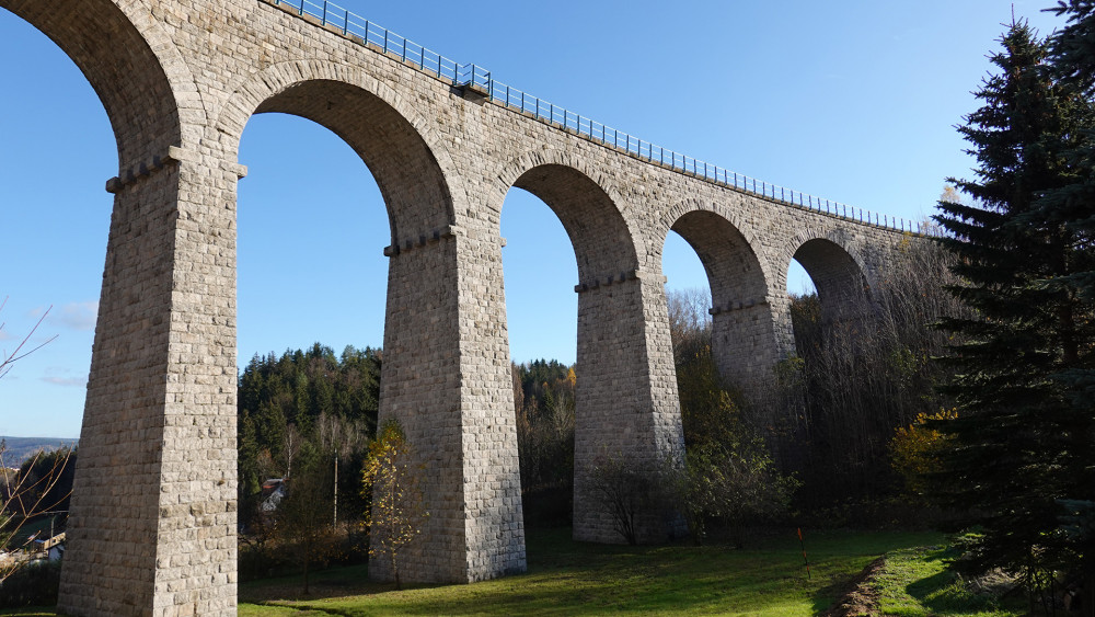 Pohled na most ze Smržovky. Viadukt má celkem 9 otvorů přemostěných půlkruhovými klenbami a měří včetně opěr celkem 123,5 m.