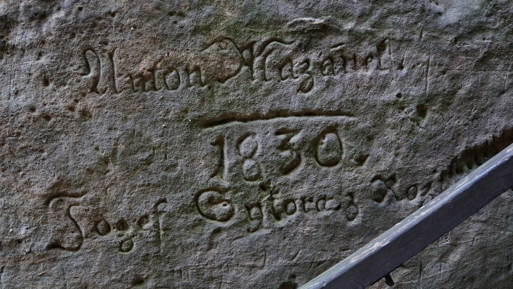 Jeden z mnoha historických epigrafických nápisů "zdobících" stěny Klokočských průchodů. Je to historická památka, nebo historický vandalismus?