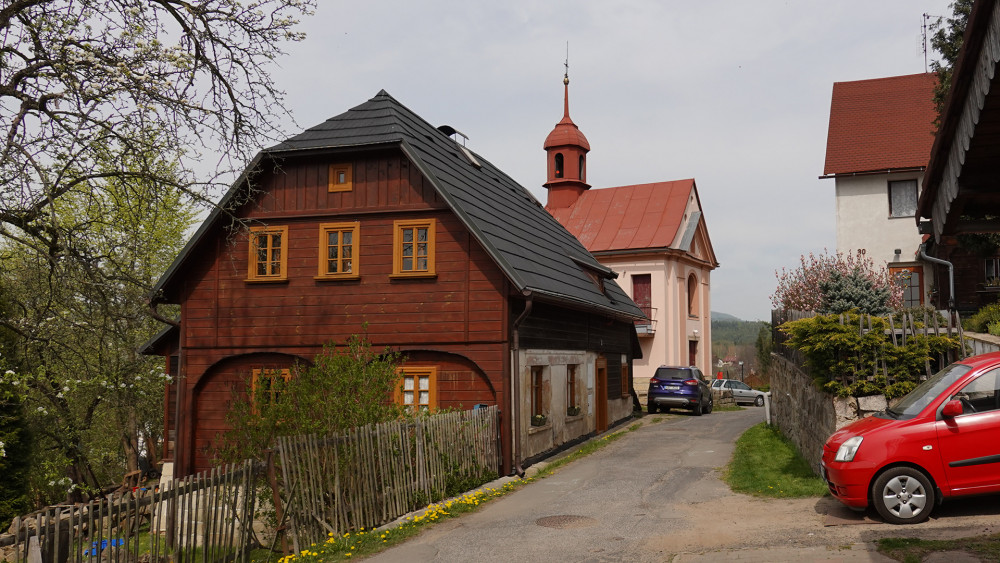 Roku 1787 si Radvanečtí postavili vlastní školní budovu (v levé části fotografie) ze dřeva stržené staré fary. V pozadí stojí kaple vysvěcená roku 1819.