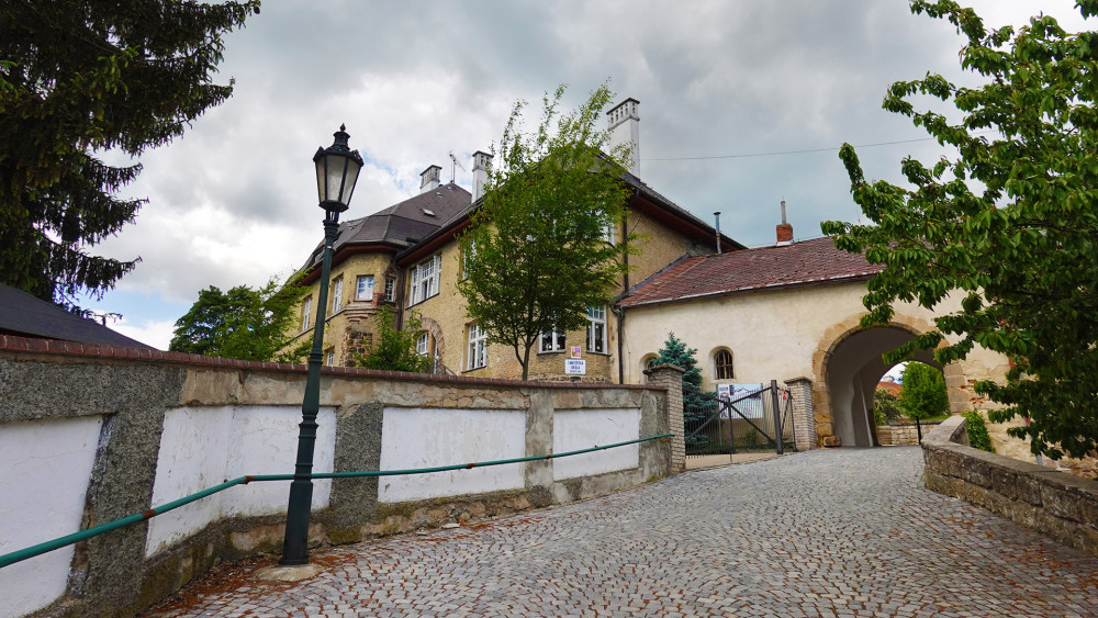 Cesta na Zámecký vrch, vlevo stojí secesní kojenecký ústav a dívčí škola z roku 1909, navazující na bránu původního středověkého opevnění. (Dnes funguje jako mateřská škola.)
